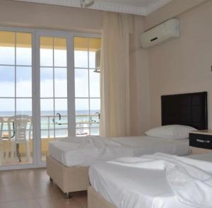 a bedroom with two beds and a view of the ocean at Kum Motel in Marmara