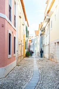 a cobblestone street in an old town with buildings at Beco dos Inválidos 67 Apartments in Cascais