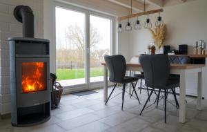 a fireplace in a living room with a table and chairs at Ferienhaus Emily in Nordhorn +31 photos