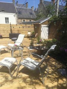 three chairs and a table on a patio at Studio à 50M de la mer avec SPA in Grandcamp-Maisy