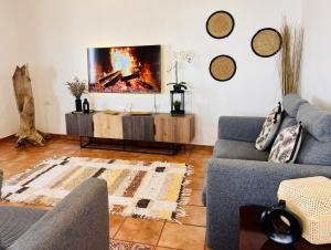 un soggiorno con un divano e una TV a parete di Lanzarote Suite Moon a Tías