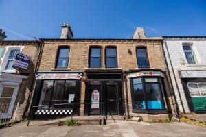 een oud bakstenen gebouw op de hoek van een straat bij The Bishops Nest in Bishop Auckland