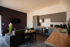 een keuken en woonkamer met een bank en een tafel bij The Bishops Nest in Bishop Auckland
