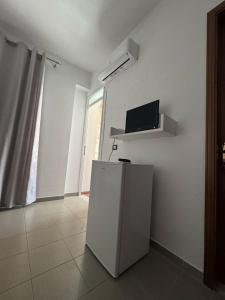 a white refrigerator in a room with a window at Viron Apartament in Himare