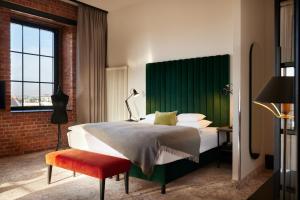 a bedroom with a large bed with a green headboard at Gastwerk Hotel Hamburg in Hamburg