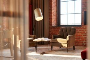 a room with a chair and a table and a window at Gastwerk Hotel Hamburg in Hamburg