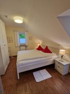 una camera da letto con un letto con cuscini rossi di Haus am Mühlenweg - modern und lichtdurchflutet a Bad Wörishofen