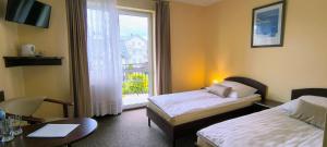 a hotel room with two beds and a window at Willa Global komfortowe pokoje nad morzem in Jastrzębia Góra