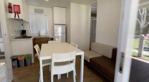 Una cocina y un comedor con mesa y sillas. en Höffmann Bungalowpark Baia Domizia - Village Baia Domizia, en Baia Domizia