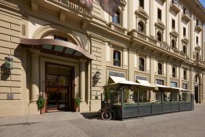 a building with an umbrella in front of it at Rocco Forte Hotel Savoy in Florence
