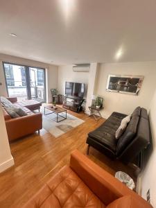 Una sala de estar con un sofá de cuero y un televisor. en Spacious 3-bed 3-Bath Luxury apartment with balcony Hyde Park, en Londres 28 fotos más