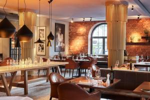 a restaurant with tables and chairs and a brick wall at Gastwerk Hotel Hamburg in Hamburg