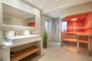 a bathroom with a white sink and a shower at Ocean House - mittendrin und trotzdem ruhig in Westerland (Sylt) +20 photos