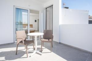 a table and chairs in a room with a dining room at Mando Living -Faliraki in Faliraki