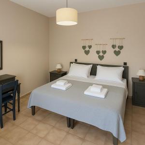 a bedroom with a large bed with two towels on it at Nicolas Beach in Palaiochora