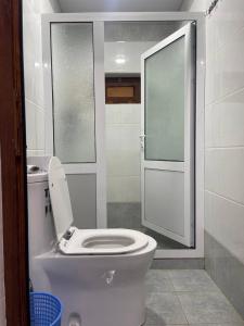 a bathroom with a toilet and a glass shower at Yaxshigulhomestay in Yukary-Ukhum