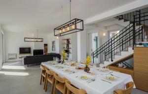 a dining room with a white table and chairs at Villa Lun T - Island Pag by Villas Guide in Lun