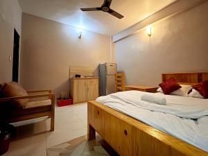 a bedroom with a large bed and a refrigerator at Amigo Studio Inn Pokhara in Pokhara