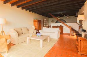 un soggiorno con divani bianchi e tavolino da caffè di Blue OceanView Relaxing Cottage a Mosteiros