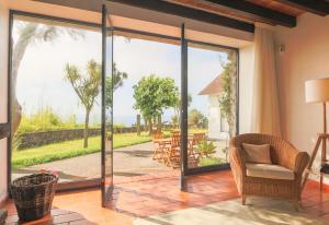un soggiorno con porte scorrevoli in vetro che si aprono su un patio. di Blue OceanView Relaxing Cottage a Mosteiros Altre 15 foto