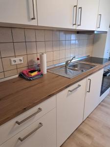 a kitchen with a sink and a wooden counter top at Nestwerk Denkmal M38-32 - am Marktplatz, Work & Relax in Biberach an der Riß