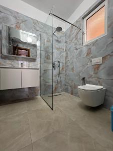 a bathroom with a shower and a toilet and a sink at Viron Apartament in Himare