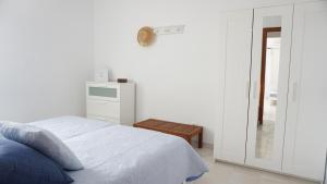 エス・カロにあるAstbury Apartments Ses Platgetesの白いベッドルーム(ベッド1台、テーブル付)