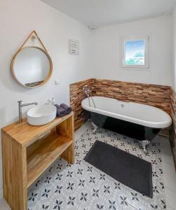 a bathroom with a tub and a sink and a mirror at Bois Lurette - Stella-Plage - Maison proche plage et centre-ville in Cucq