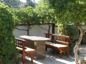 two benches and a table and two trees at Villa Pagar - with hydromassage pool, pets friendly in Povljana
