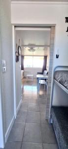 a hallway of a room with a table and a bed at Studio Cabine Vue Port avec parking privé in Cap d'Agde +14 photos