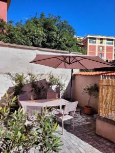 a table and chairs under an umbrella on a patio at Via Alla Spiaggia in Lavagna