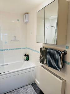 IfieldにあるFly Hi-Town Centre Apartmentの浴槽と鏡のある白いバスルーム