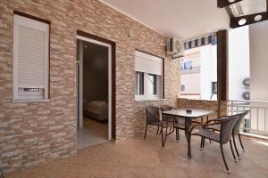 a dining room with a brick wall and a table and chairs at GARBIS Μπακάλης Θεοχάρης in Leptokarya