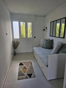 a white living room with a couch and windows at Appartement vu mer et montagnes in Villeneuve-Loubet +5 photos