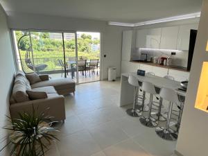 a kitchen and living room with a couch and a table at Appartement vu mer et montagnes in Villeneuve-Loubet
