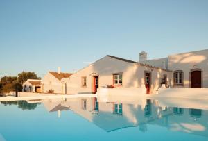 a house reflecting in the water of a swimming pool at Quinta do Pinheiro in Pinheiro