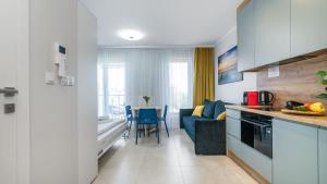 a kitchen and living room with a couch and a table at PERŁA MIERZEI Apartamenty Piamola in Sztutowo