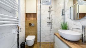 a bathroom with a sink and a shower at PERŁA MIERZEI Apartamenty Piamola in Sztutowo