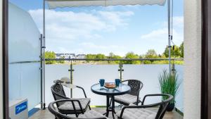 a balcony with a table and chairs and a view at PERŁA MIERZEI Apartamenty Piamola in Sztutowo +7 photos