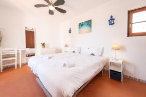 een slaapkamer met een groot wit bed en een plafondventilator bij Algarve 3-Bedroom Villa w Pool, Beaches & Golf in Tavira