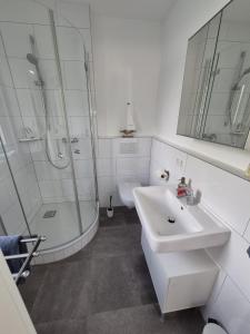 Un baño blanco con lavabo y ducha. en Fewo Schlossbühl, en Meersburg 12 fotos más