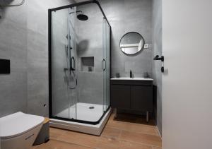 a bathroom with a glass shower and a sink at Modern Design Old Town Apartment by MN Property in Kotor +50 photos
