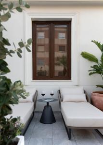 a patio with two couches and a table with glasses of wine at Coliseum Boutique Apartments in Córdoba +101 photos