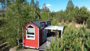 a red and black tiny house in the woods at Tajnikowo Sekretny Tiny House Anyżek in Łubiana