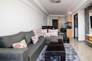Una sala de estar con un sofá gris y una mesa de café. en Faith Ajema, en Nairobi