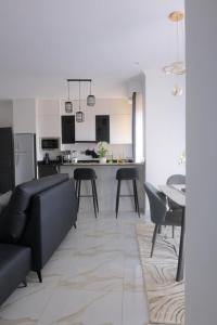un soggiorno con un divano nero e una cucina di Nisrab Apartments Najjera Kampala a Kampala