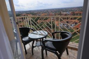 due sedie e un tavolo su un balcone con vista di Nisrab Apartments Najjera Kampala a Kampala