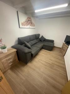 a living room with a gray couch in a room at Casa en el centro del pueblo in El Morell