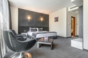 a hotel room with a bed and a chair at Hotel Noris in Plovdiv
