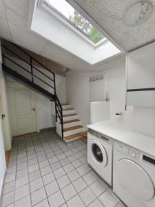 a kitchen with a washer and dryer in a room at Riverview Cottage in Randbøl